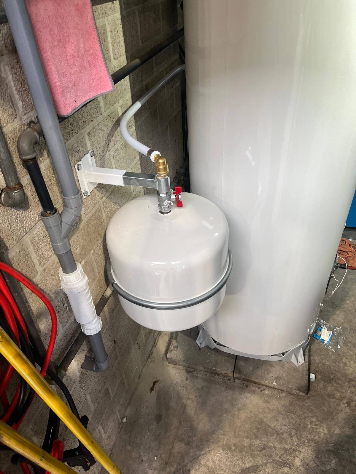 Detail van een expansievat aangesloten op een boiler, met zichtbaar leidingwerk.